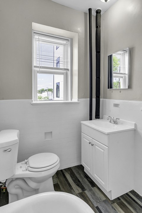 a bathroom with a toilet and a sink and a window