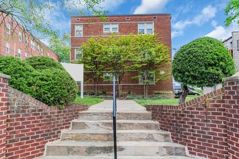 the front of a brick building with stairs in front of it
