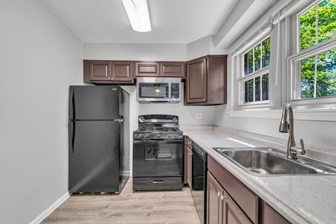 an updated kitchen with stainless steel appliances and wood cabinets