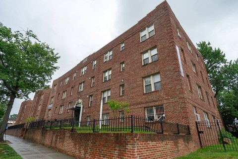 a large brick building with a sidewalk in front of it