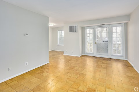 A room with a wooden floor and a sliding glass door.