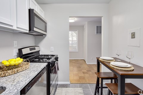 A kitchen with a black stove top oven and a black microwave above it.