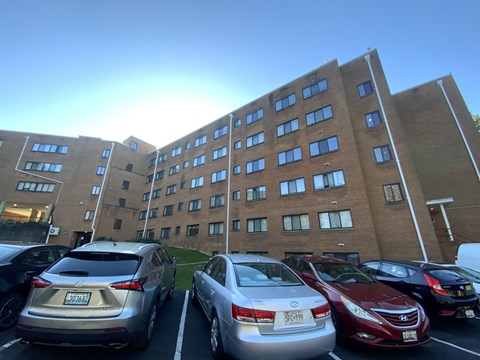 Cars parked in a parking lot in front of a brick building.
