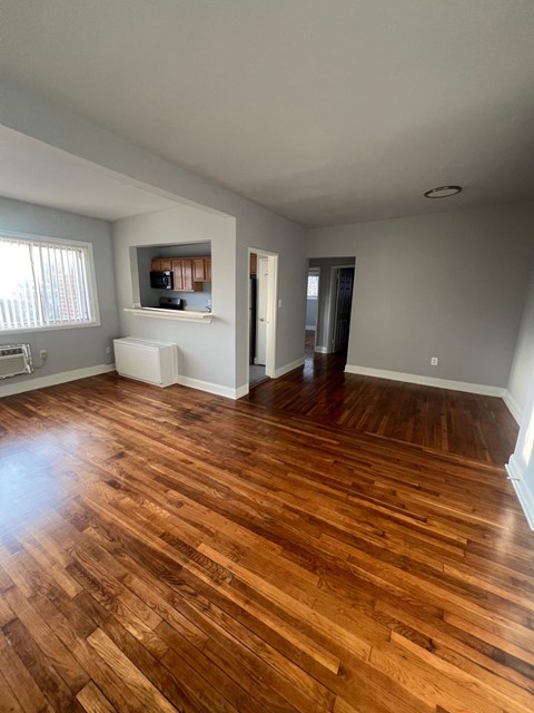 A room with wooden flooring and a window.