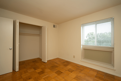 a bedroom with a large window and a door to a closet