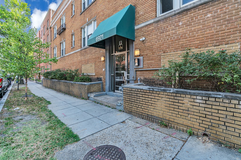a brick building with a green awning and a sidewalk