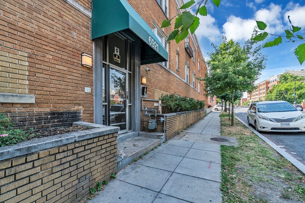 a brick building with a car parked on the sidewalk