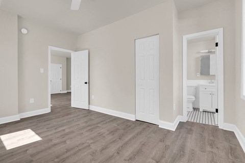 A spacious room with a white door and a white cabinet in the bathroom.