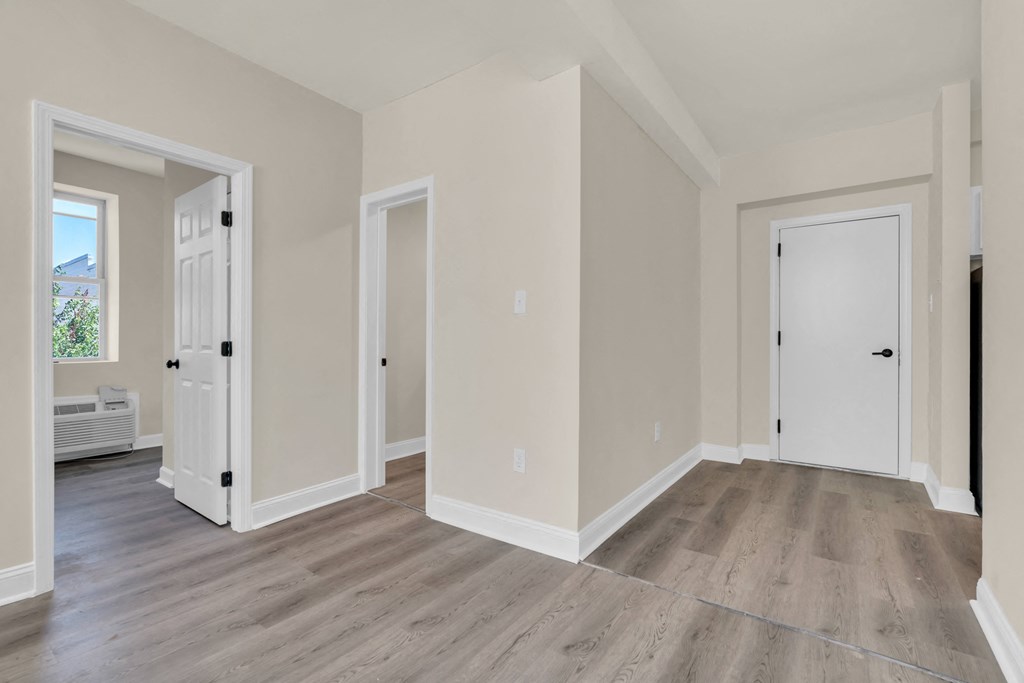 a living room with wood floors and white walls and doors