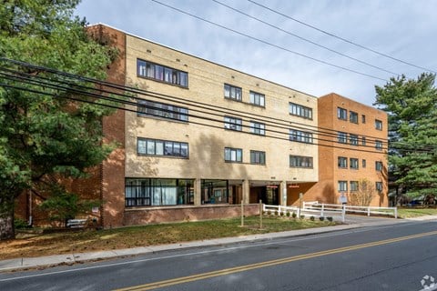 A brown building with a white fence in front.
