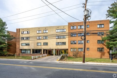 A large brick building with a white fence in front.