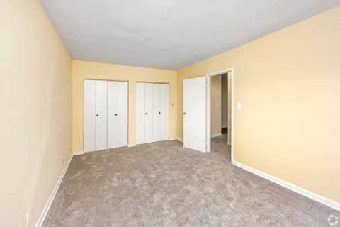 A room with a carpeted floor and a white door.