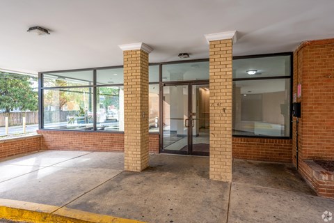 A building entrance with a glass door flanked by two pillars.
