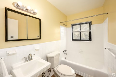 A bathroom with a white toilet, sink, and bathtub.