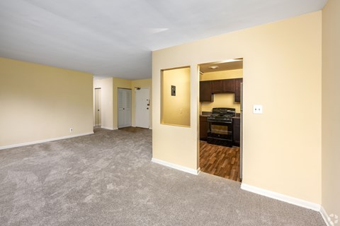 A room with a carpeted floor and a doorway leading to another room.