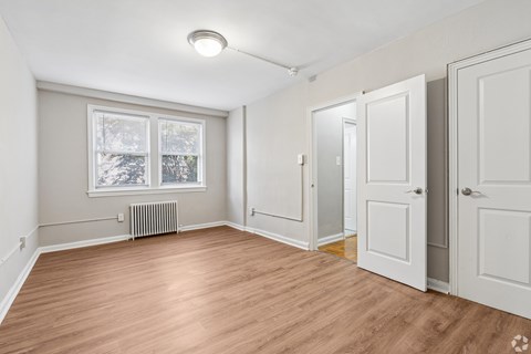 A room with a window and a radiator on the wall.