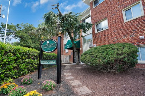 A brick building with a sign that says "Bloomfield Apartments Leasing Office".