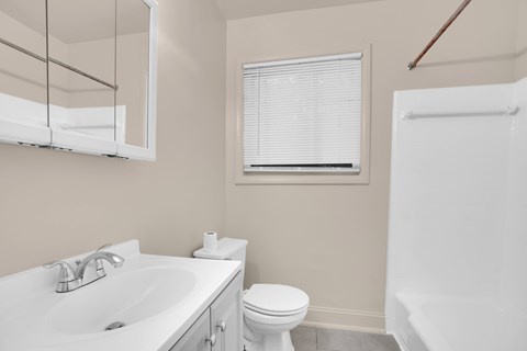 A white toilet sits next to a sink in a bathroom.