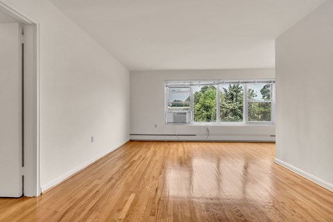 A room with wooden floors and a large window.