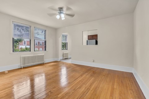 A room with wooden floors and a ceiling fan.