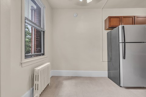 A kitchen with a refrigerator and a window.