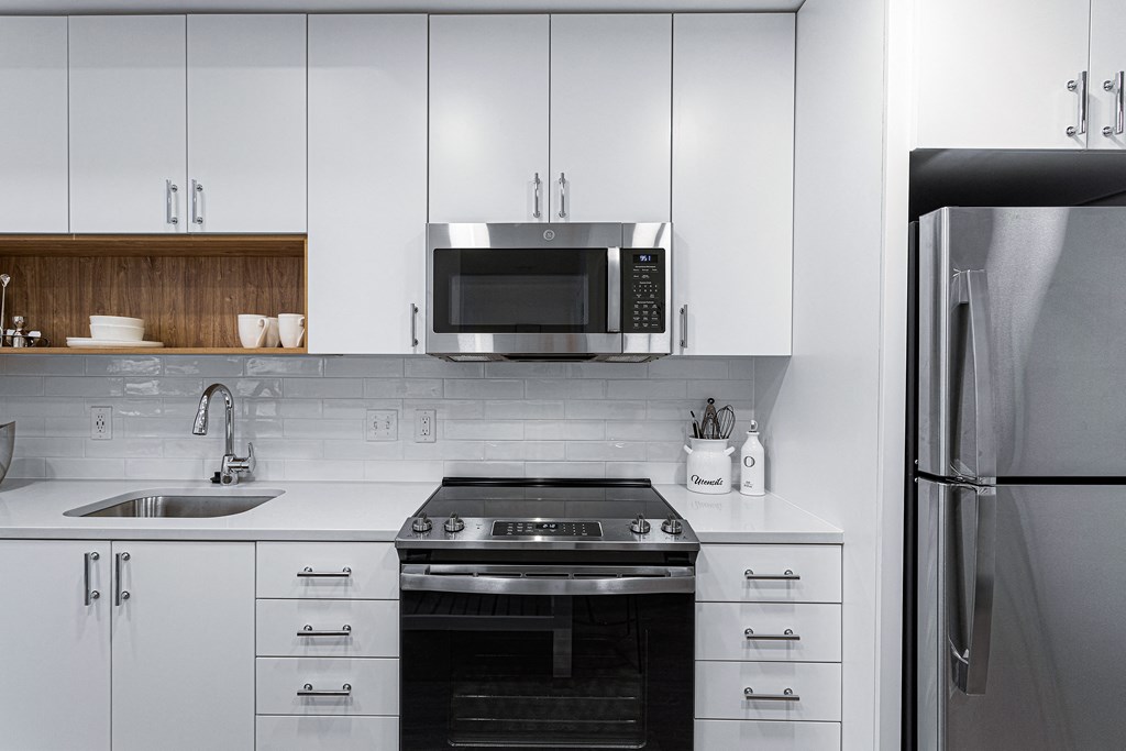 a kitchen with white cabinets and a stove and a microwave