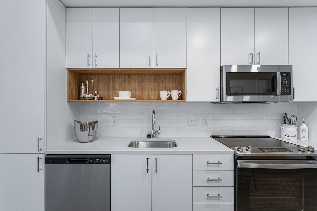 a kitchen with white cabinets and a sink and a microwave