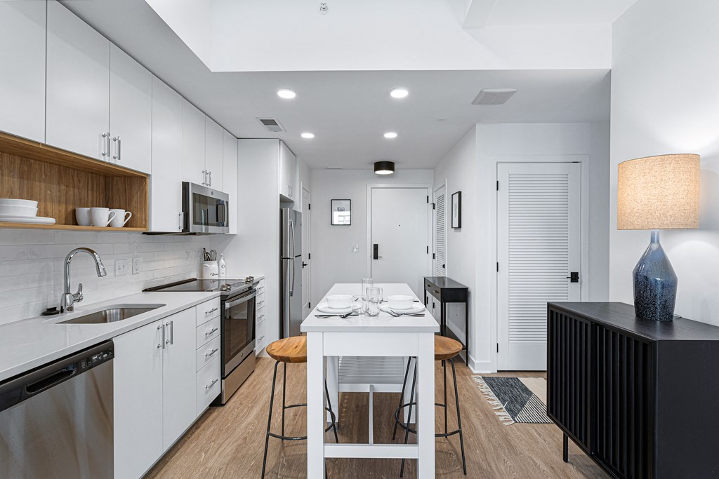a large kitchen with white cabinets and a white table