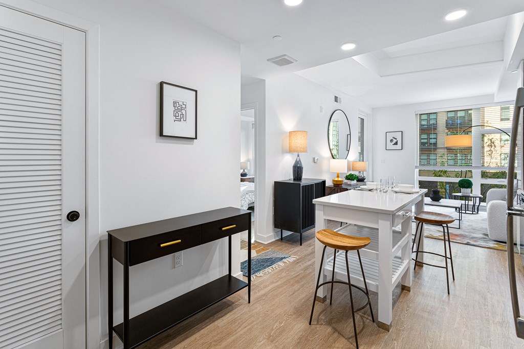 an open kitchen and living room with a white island and a table with chairs