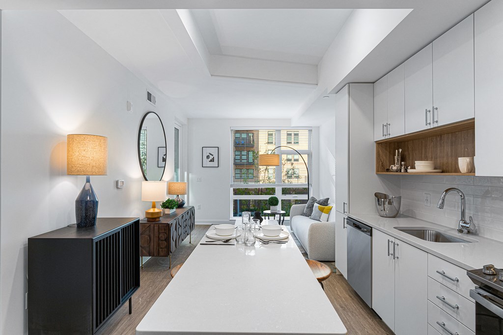 an open kitchen and living room with a large white table