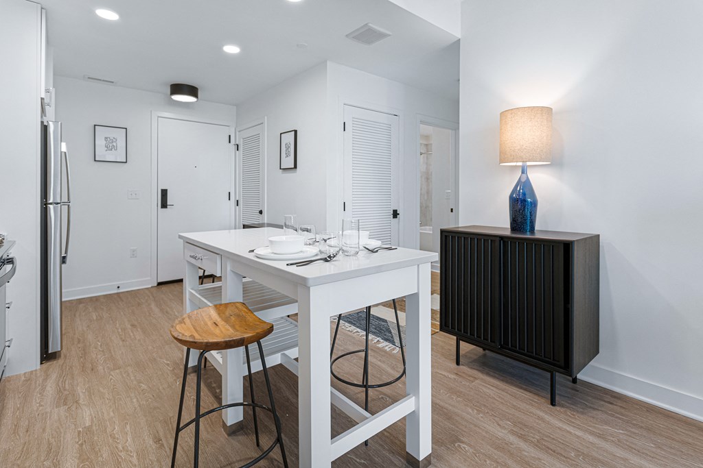 a white kitchen with a white island and stools