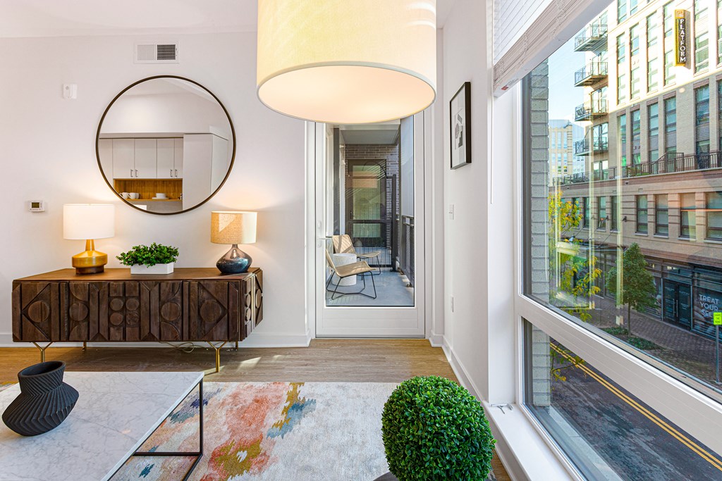 a living room with a large window and a door to a balcony