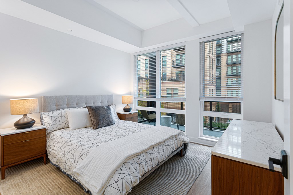 a bedroom with a bed and a large window