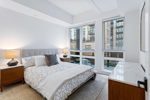 a bedroom with a bed and a large window