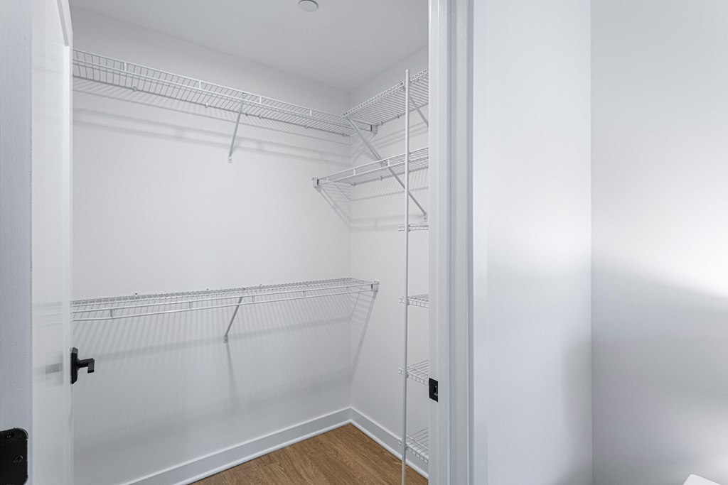 a closet with white walls and white shelves and a white closet door