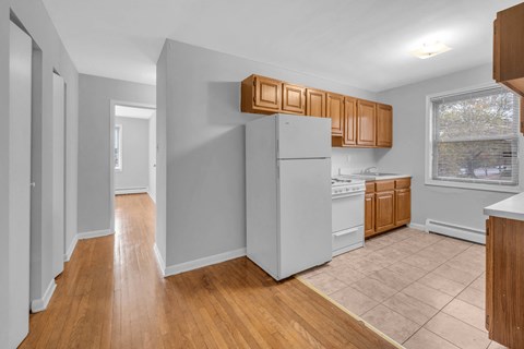 A kitchen with wooden cabinets and a white refrigerator.