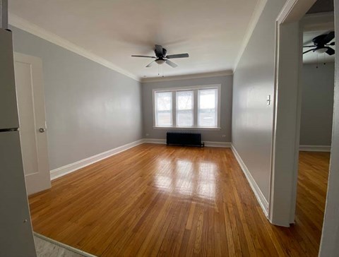 A room with wooden floors and a ceiling fan.