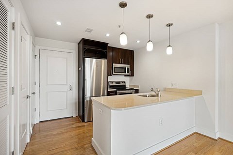 A kitchen with a white counter and a stainless steel refrigerator.