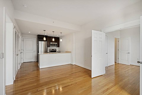 A spacious room with wooden floors and white walls.