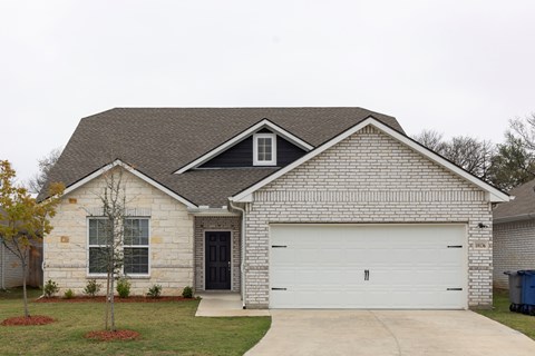 A house with a white garage door and a black door.