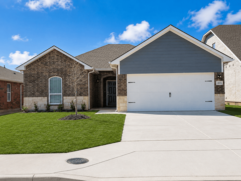 A house with a grey garage door and a brick exterior.