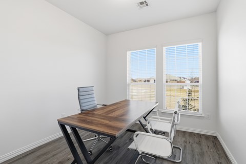 A room with a table and chairs and a window.