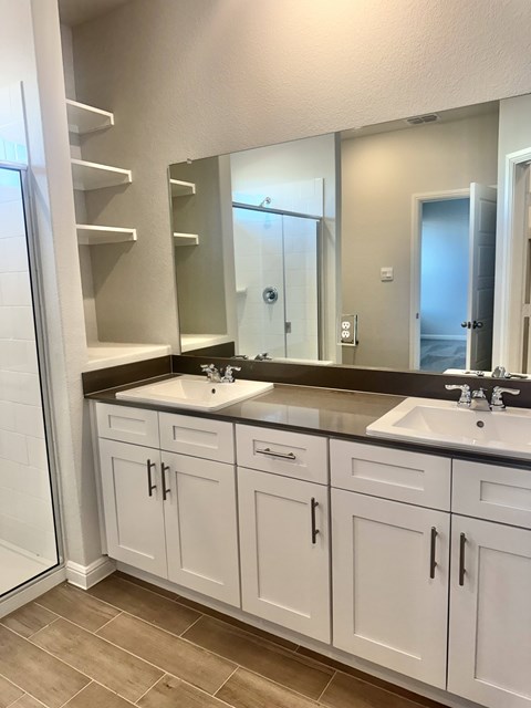 A bathroom with two sinks and a large mirror.