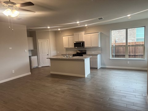 A spacious kitchen with a fan and a countertop.
