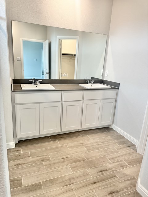 A bathroom with two sinks and a large mirror.