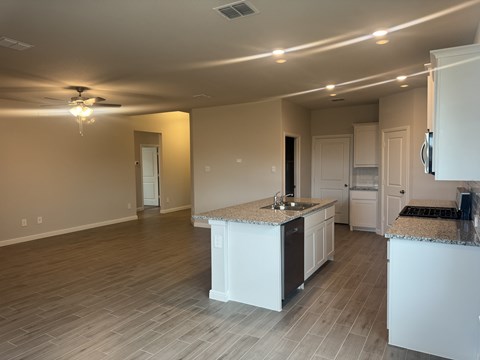 A kitchen with white cabinets and a countertop is shown.