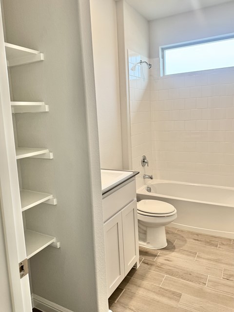 A white bathroom with a toilet and a bathtub.
