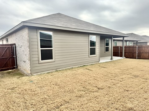 A house with a grey roof and a brown fence.