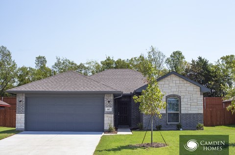 A house with a garage door numbered 107 is for sale by Camden Homes.