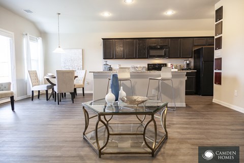A modern kitchen and dining area with a glass table and chairs.